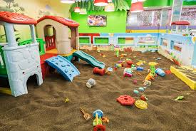 Indoor sandbox and playground at a daycare.